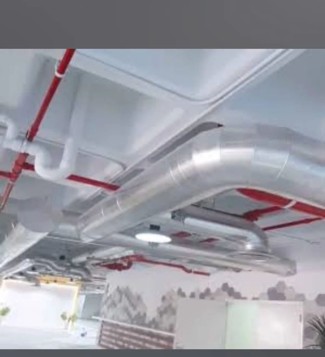 Exposed metal duct alongside fire-protection services